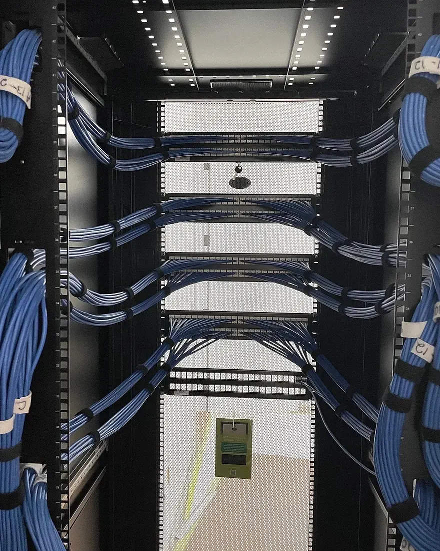 Blue Cat6 bundles dressed down both rails of a finished floor rack